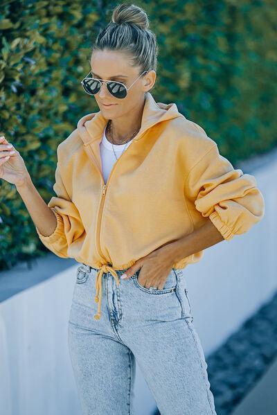 a woman wearing a yellow jacket and sunglasses