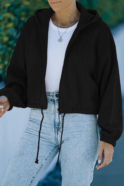 a woman wearing a black jacket and jeans