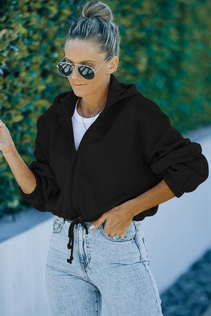 a woman wearing a black jacket and sunglasses