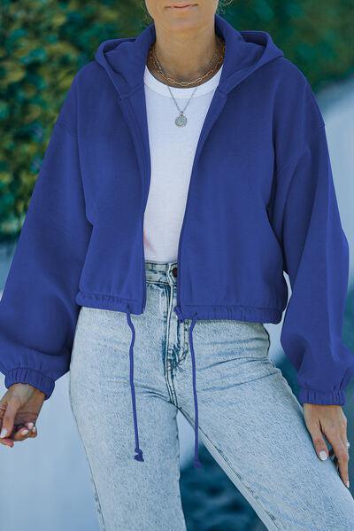 a woman wearing a blue jacket and jeans