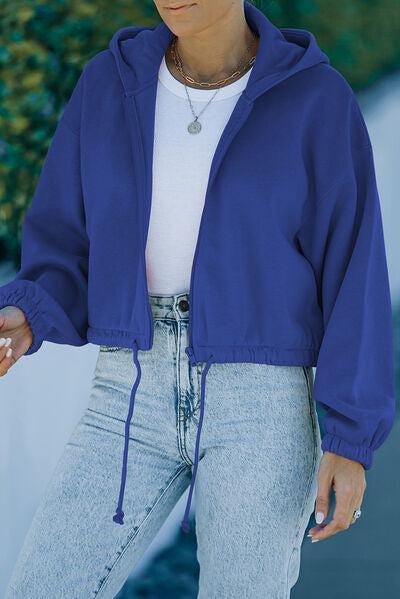 a woman wearing a blue jacket and jeans