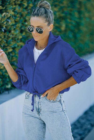 a woman wearing a blue jacket and sunglasses