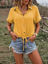 a woman wearing a yellow shirt and denim shorts