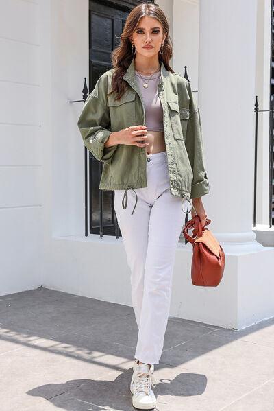 a woman in white pants and a green jacket