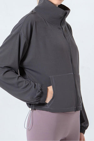 a woman wearing a black jacket and purple pants