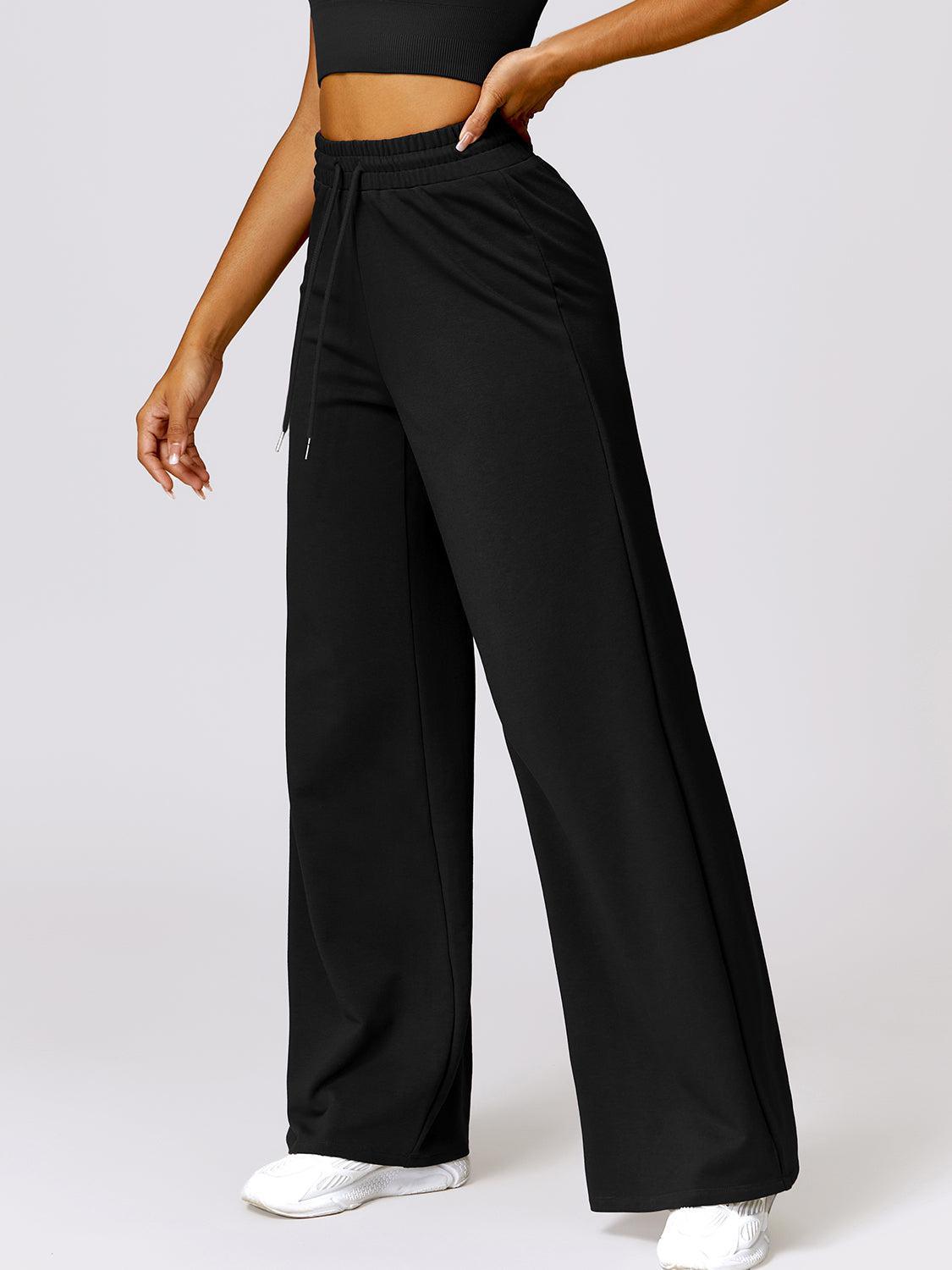 a woman in a black crop top and wide legged pants
