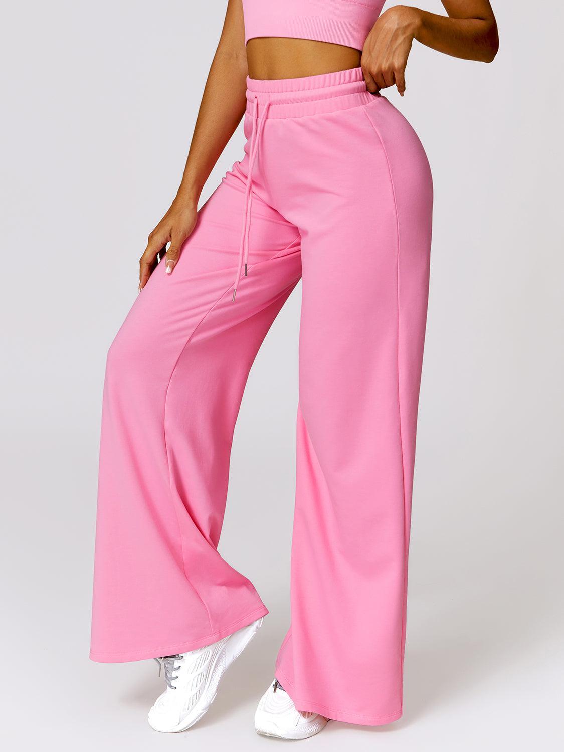 a woman in a pink crop top and wide legged pants