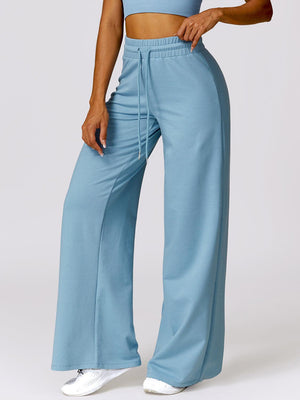 a woman wearing a crop top and wide legged pants