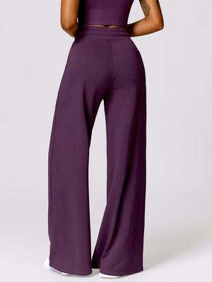 a woman wearing purple pants and a crop top