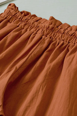 a close up of a bed with an orange comforter