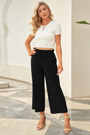 a woman in a white top and black pants