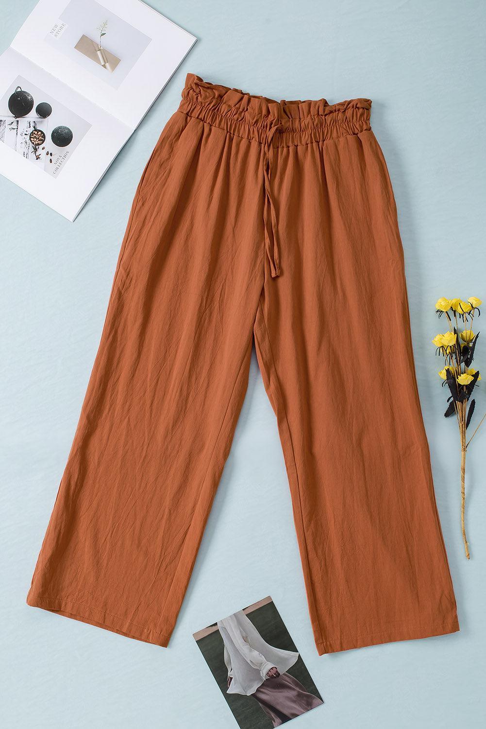 a pair of brown pants next to a yellow flower