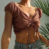 a woman wearing a brown top and jeans