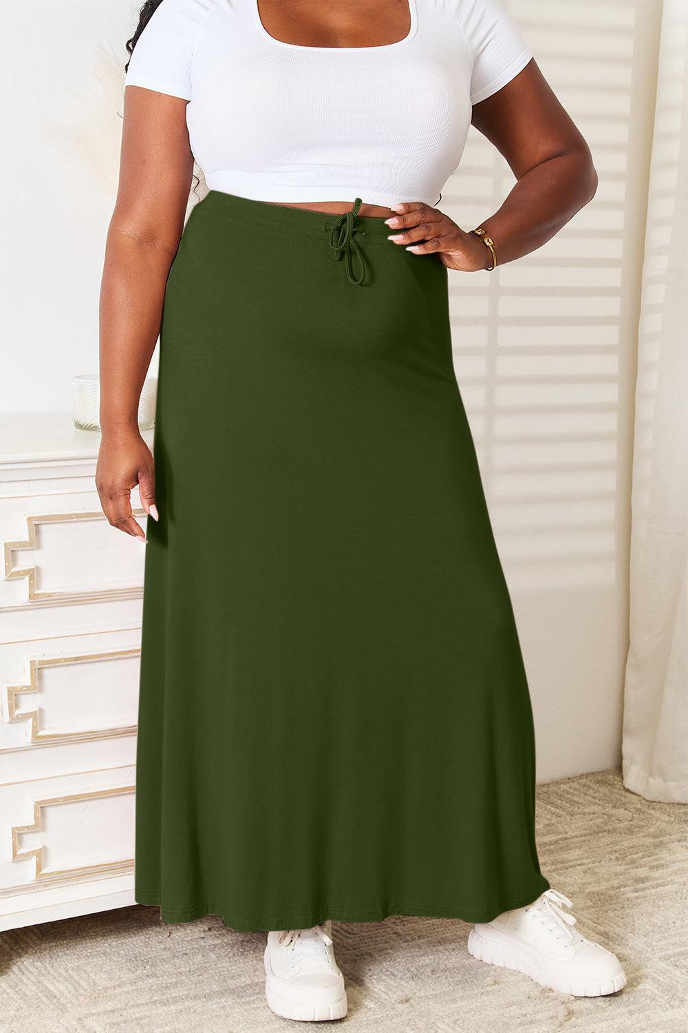 a woman in a white top and green skirt