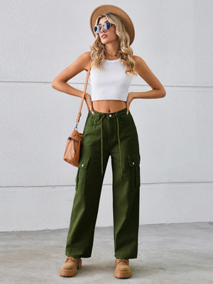 a woman wearing green cargo pants and a white crop top