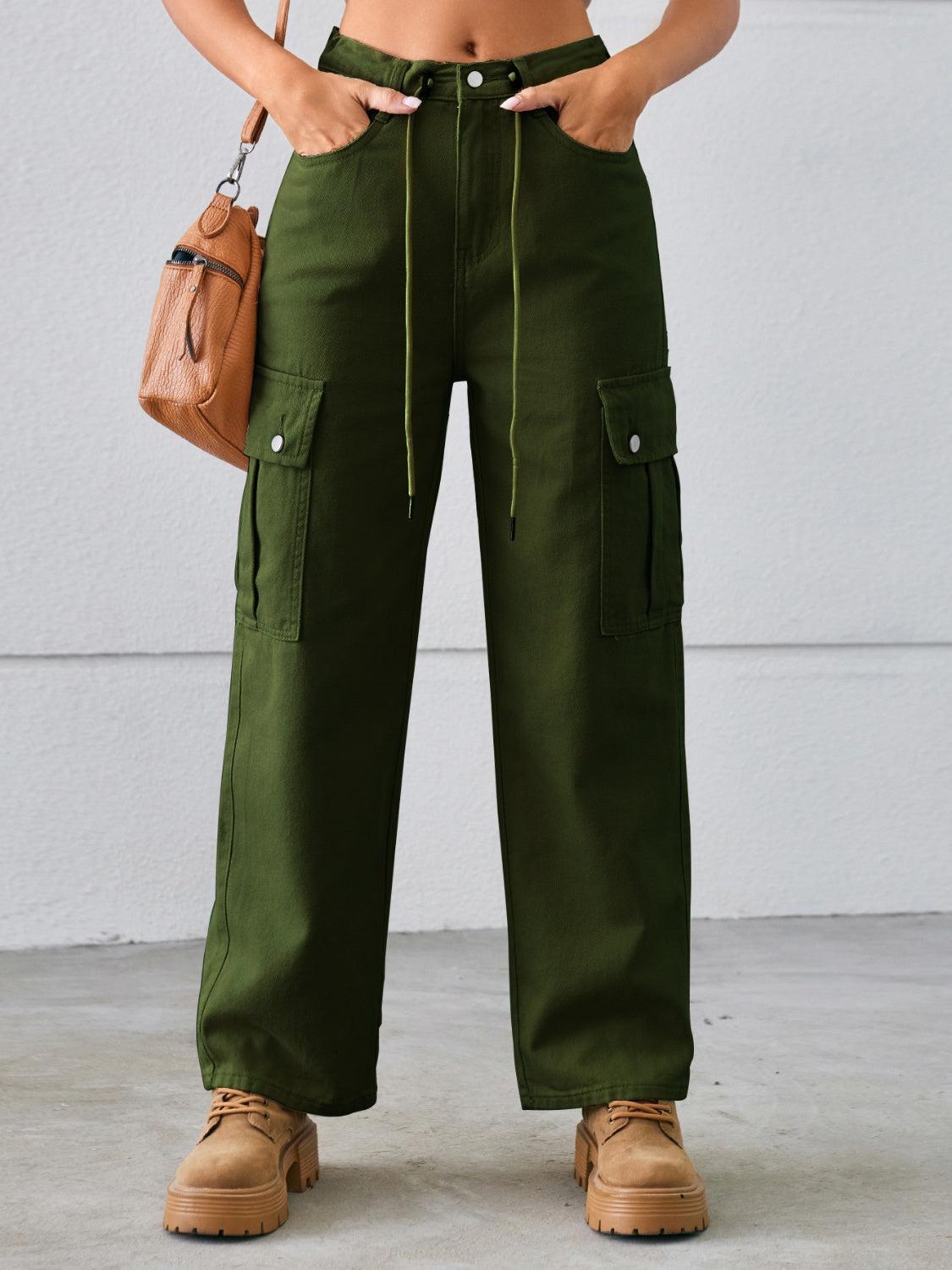 a woman wearing green pants and a crop top