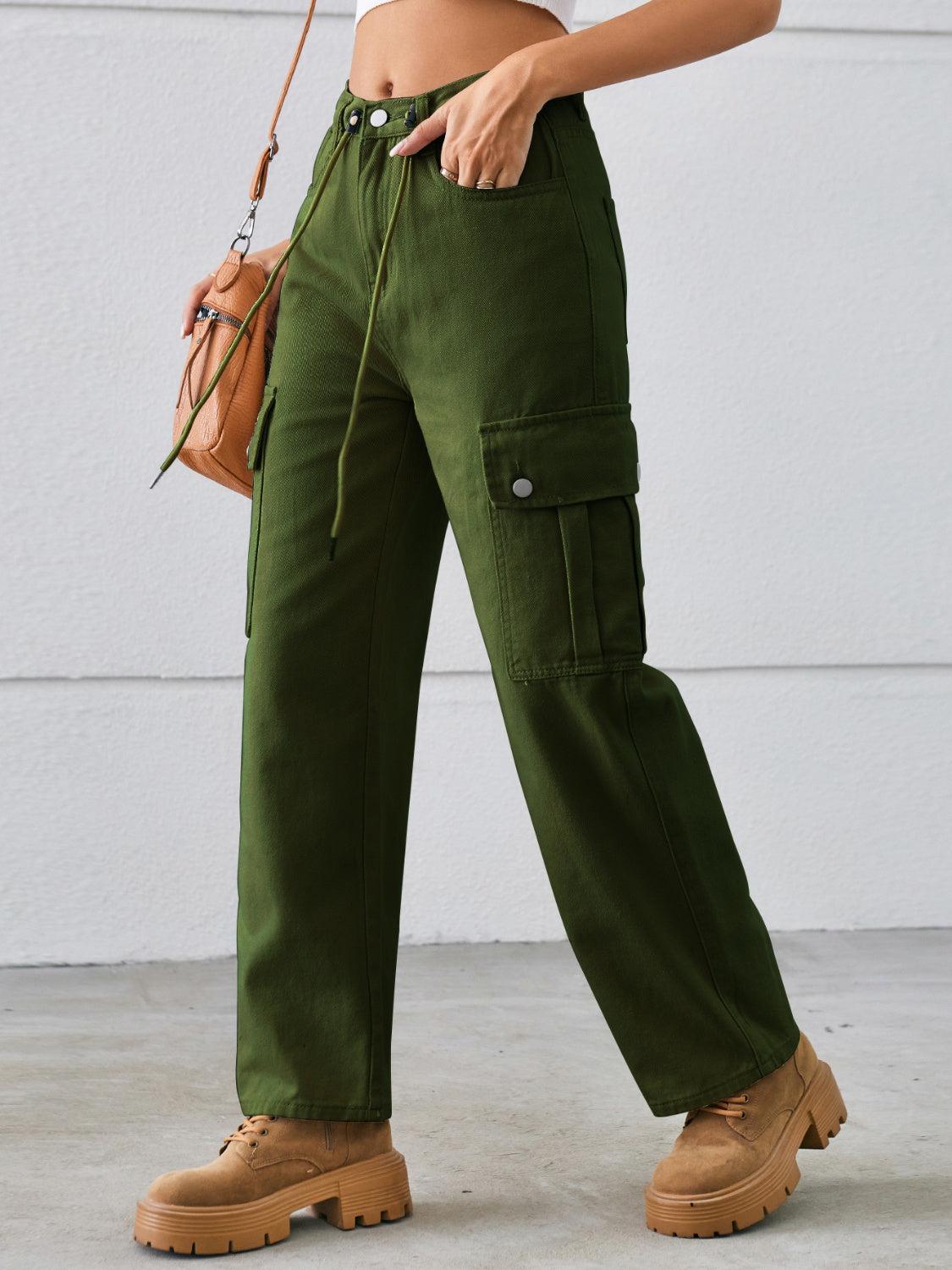 a woman in a white top and green pants