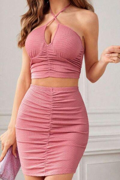 a woman wearing a pink two piece dress