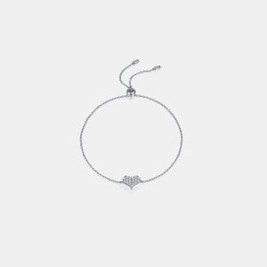 a silver bracelet with a heart charm on a white background