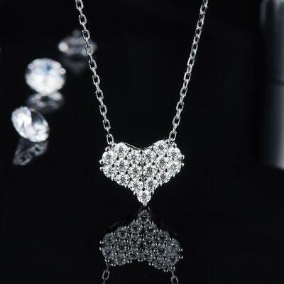 a diamond heart necklace and earring set on a black surface