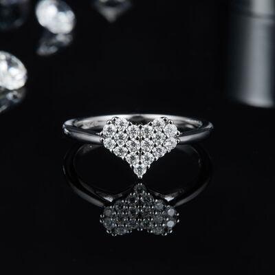 a heart shaped diamond ring sitting on top of a table