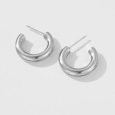 a pair of silver hoop earrings on a white background