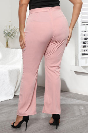 a woman in a black top and pink pants