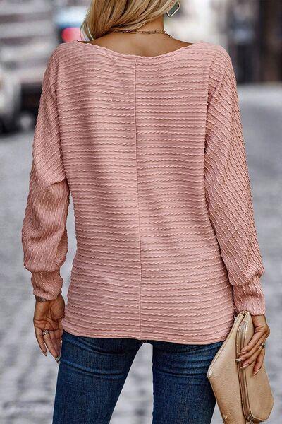 a woman wearing a pink sweater and jeans