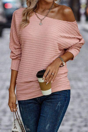 a woman wearing a pink sweater and jeans