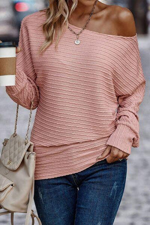 a woman in a pink sweater holding a cup of coffee