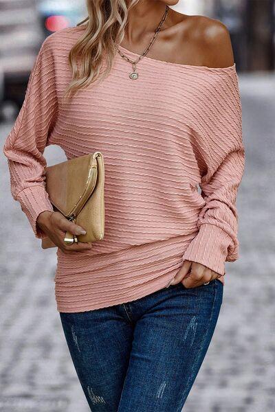 a woman wearing a pink sweater and jeans