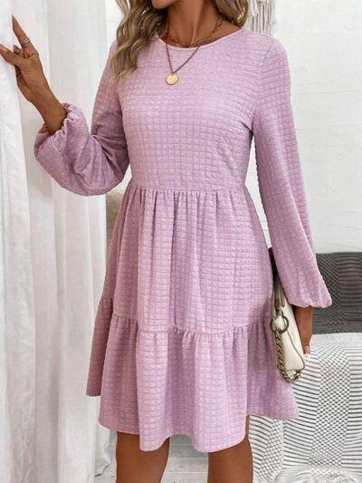 a woman wearing a pink dress with long sleeves