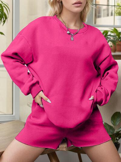 a woman sitting on a chair wearing a pink sweatshirt and shorts