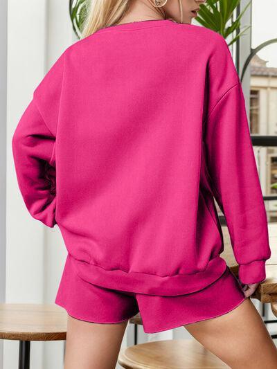 a woman wearing a pink sweatshirt and shorts