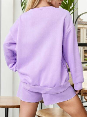a woman wearing a purple sweatshirt and shorts