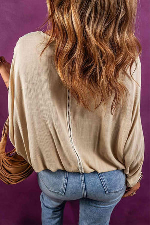 the back of a woman's body wearing a tan top