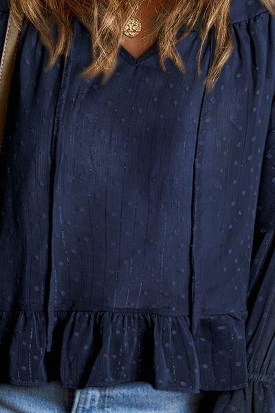 a close up of a woman wearing a blue blouse