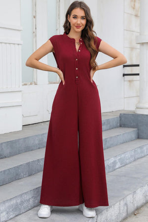 a woman in a red jumpsuit standing on steps