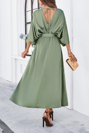 a woman wearing a green dress and heels