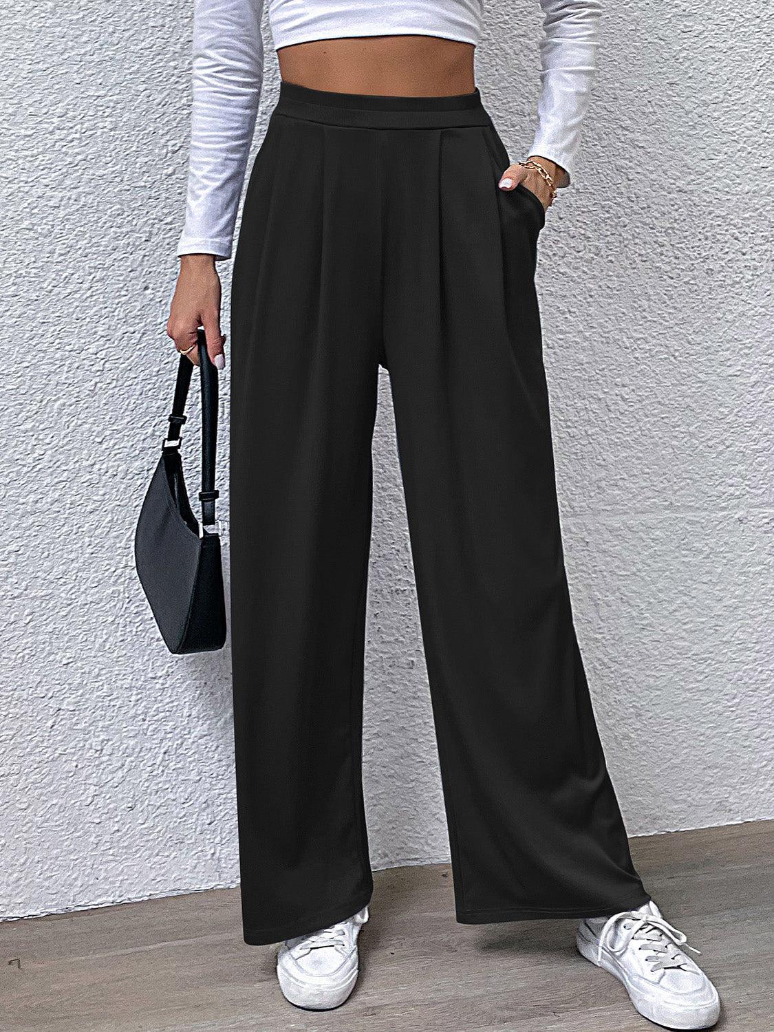 a woman in a white top and black pants