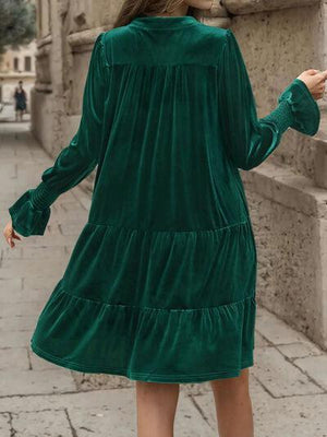 a woman in a green dress walking down a street