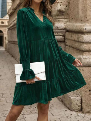 a woman wearing a green dress and hat