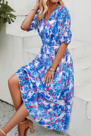 a woman in a blue and red dress sitting on steps