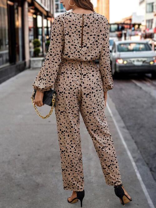 a woman in a leopard print jumpsuit is walking down the street