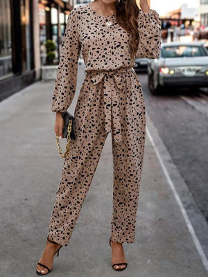 a woman in a leopard print jumpsuit is talking on a cell phone