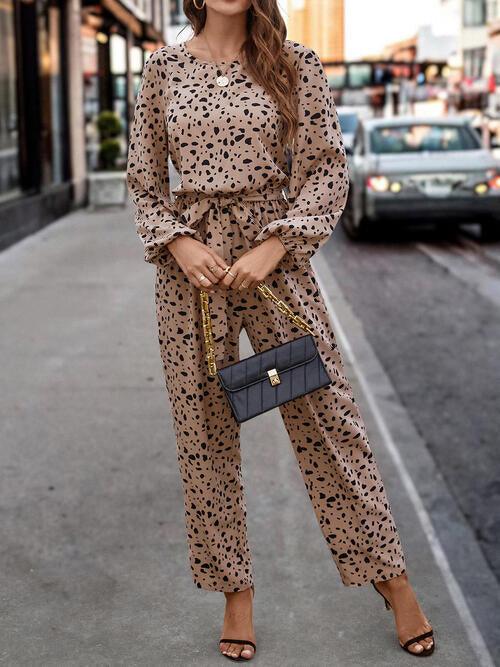 a woman in a leopard print jumpsuit posing on the street