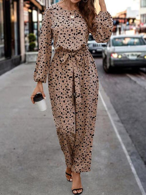 a woman walking down the street in a leopard print dress