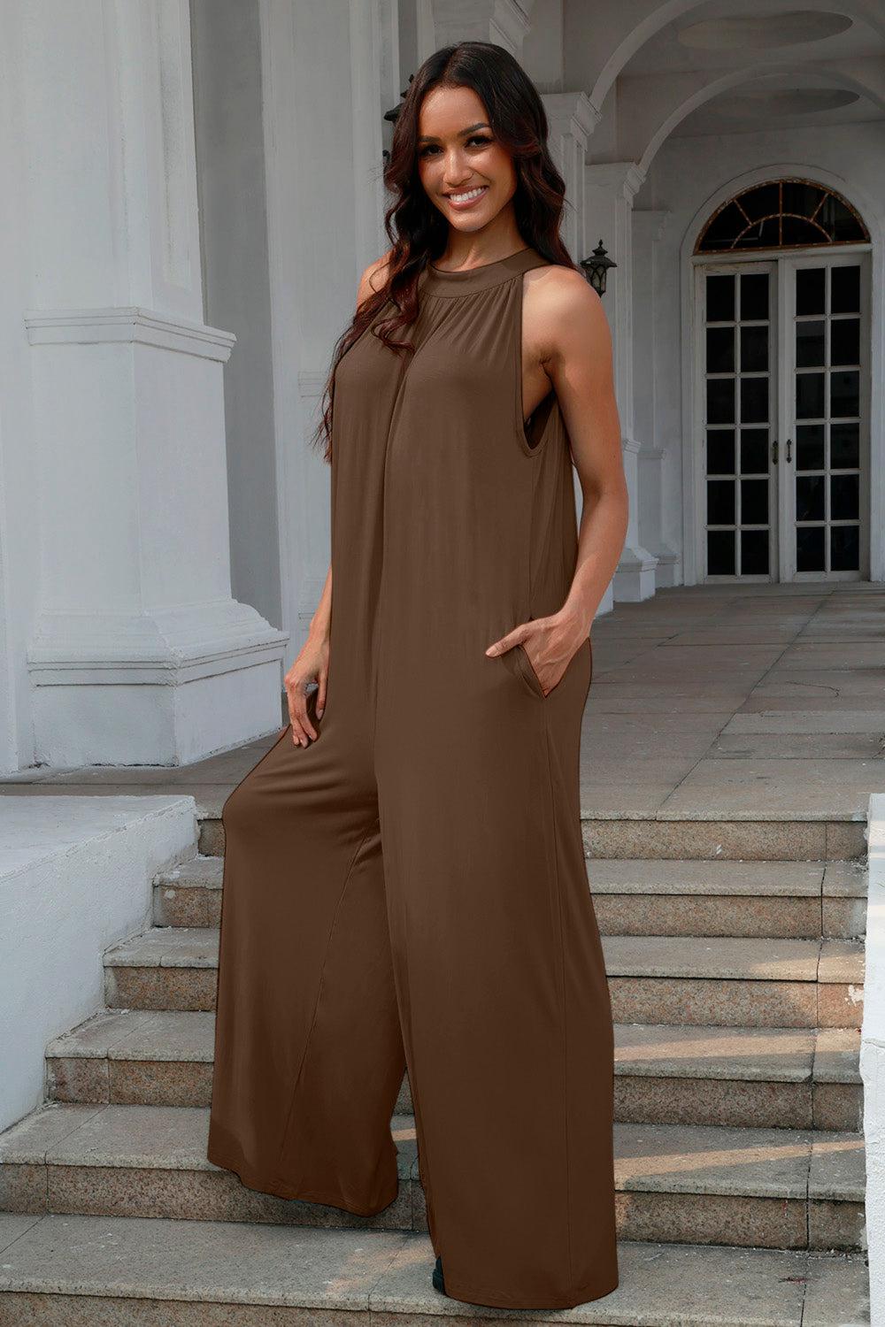 a woman in a brown jumpsuit standing on some steps