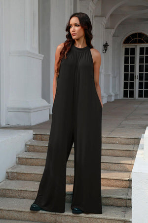 a woman in a black jumpsuit standing on some steps