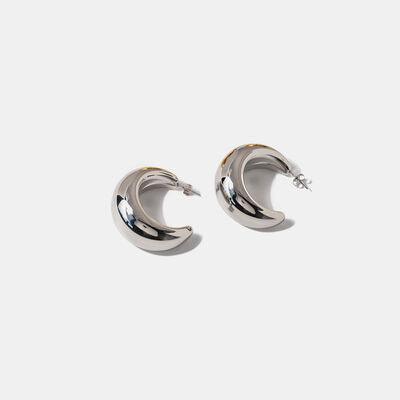 a pair of silver hoop earrings on a white background